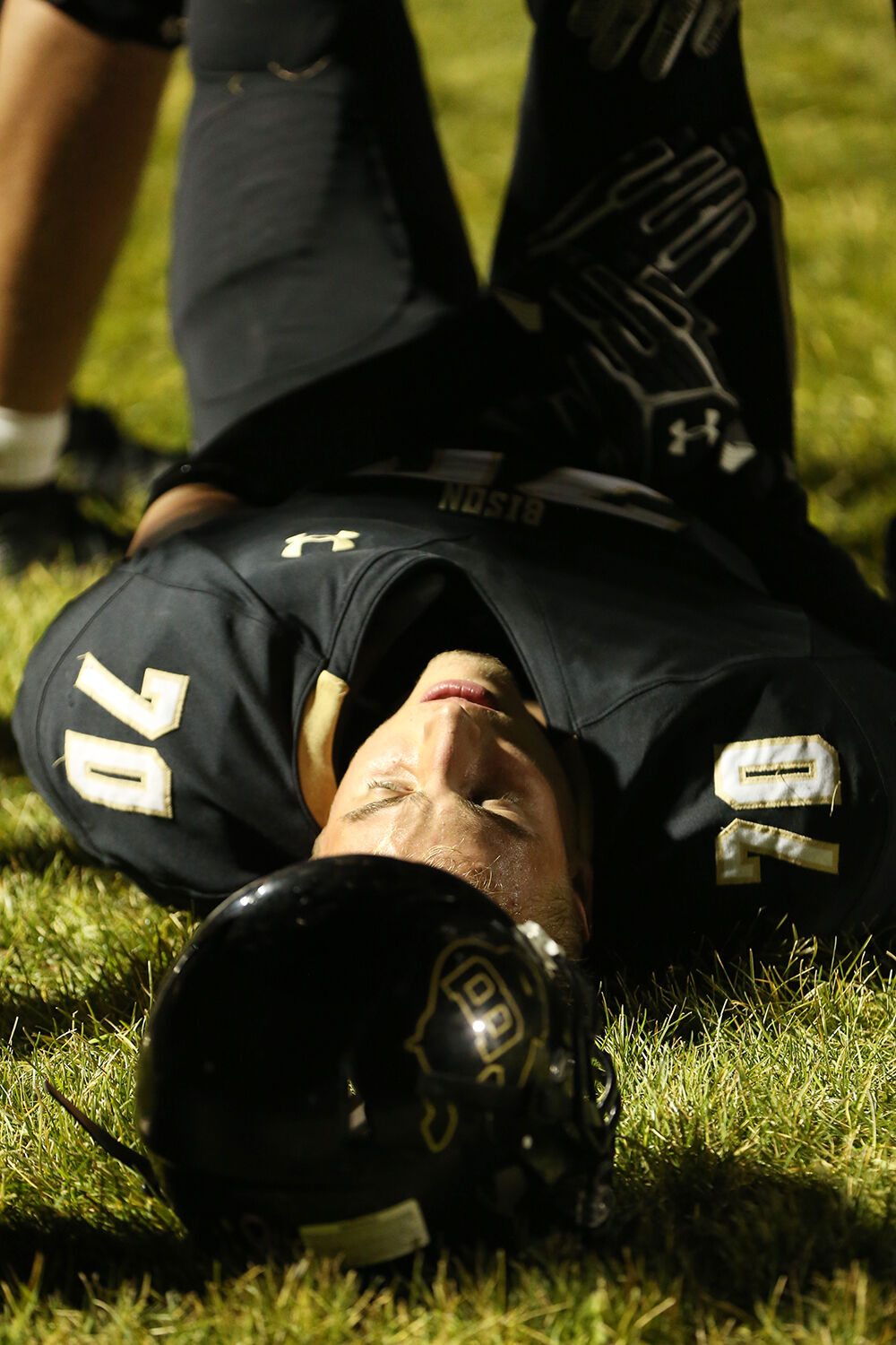 Aidan O’Neill lays on the ground as his teammates stretch his legs